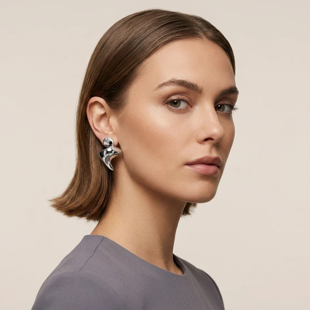Model wearing rhodium sculptural earrings